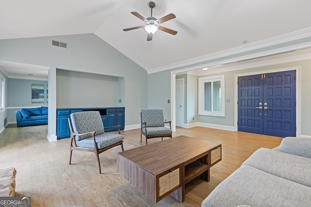 living room with crown molding, vaulted ceiling, and light wood-type flooring