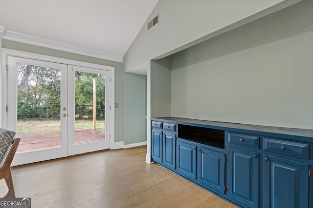 interior space with vaulted ceiling, ornamental molding, light hardwood / wood-style floors, and french doors