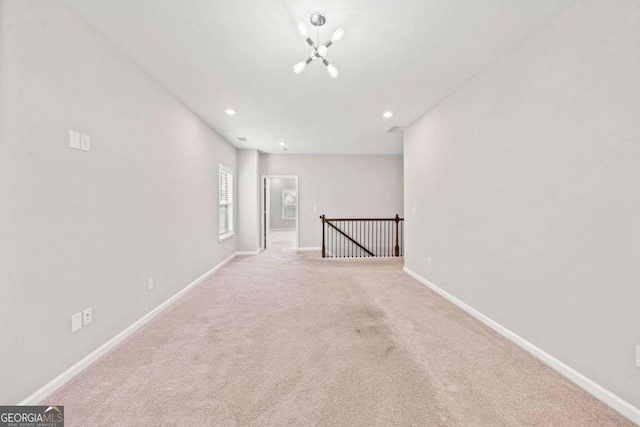 spare room with carpet, a notable chandelier, baseboards, and recessed lighting