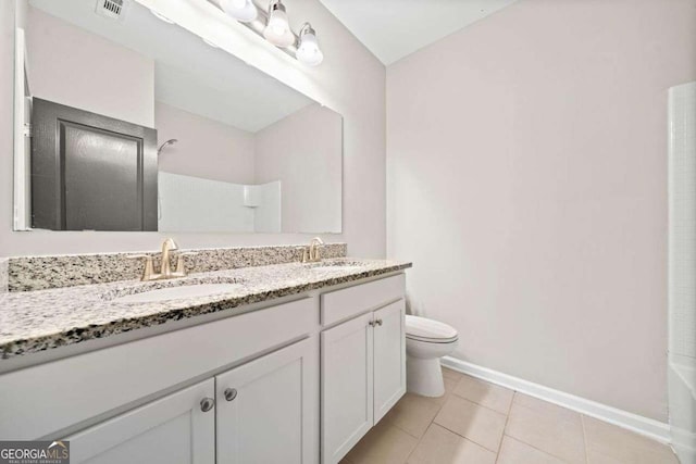 full bathroom with double vanity, baseboards, toilet, tile patterned floors, and a sink