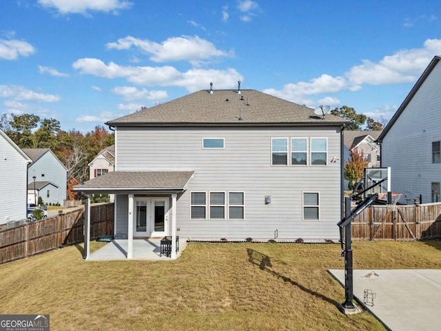 rear view of property with french doors, a patio area, a yard, and a fenced backyard