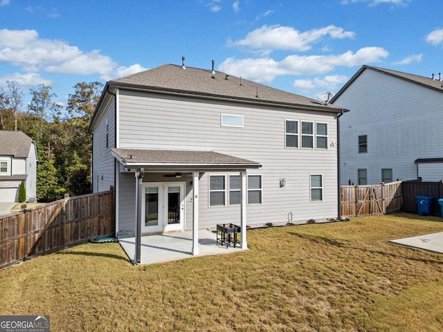 rear view of property featuring a fenced backyard, french doors, a lawn, and a patio