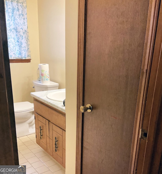 bathroom featuring tile patterned floors, vanity, and toilet