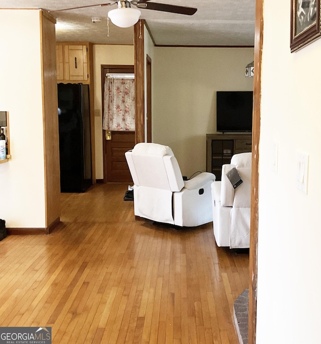 living room with ceiling fan, ornamental molding, and hardwood / wood-style floors