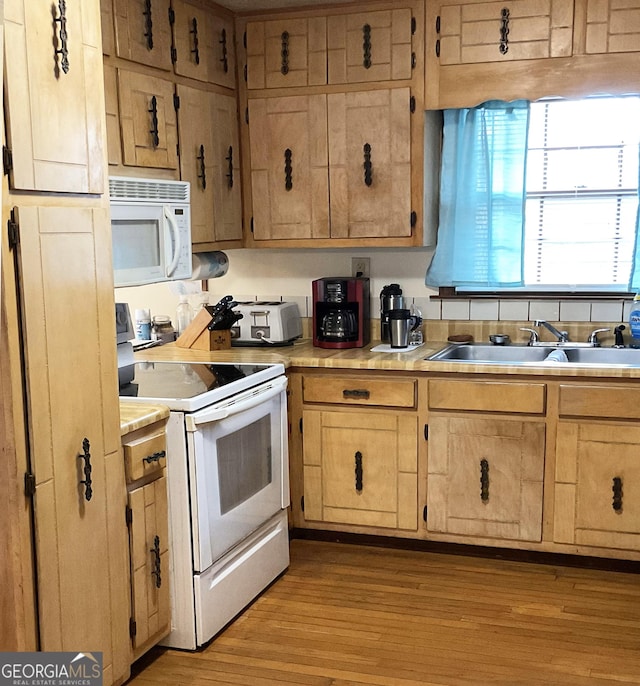 kitchen featuring sink, white appliances, and light hardwood / wood-style floors