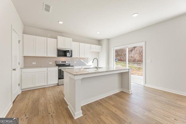 kitchen with stainless steel appliances, sink, a center island with sink, and white cabinets