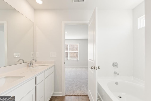 bathroom featuring vanity and a tub