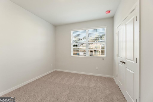 spare room featuring light colored carpet