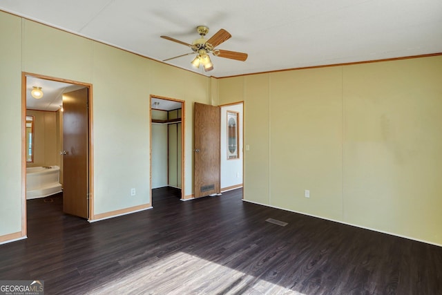 unfurnished bedroom featuring ornamental molding, ceiling fan, dark hardwood / wood-style flooring, and ensuite bath