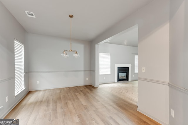 3236 Tallon Ln SW, Atlanta, GA 30311 - unfurnished living room with light wood-style flooring, a chandelier, and a fireplace