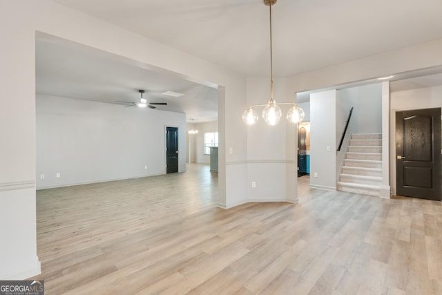 3236 Tallon Ln SW, Atlanta, GA 30311 - unfurnished room featuring light wood finished floors, a chandelier, stairs, and a ceiling fan