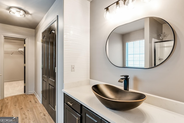 3236 Tallon Ln SW, Atlanta, GA 30311 - full bathroom featuring vanity, a spacious closet, and wood finished floors