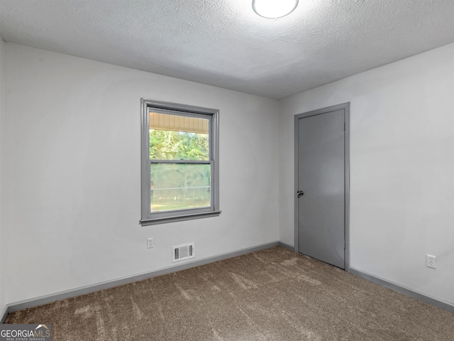 empty room featuring carpet floors and a textured ceiling