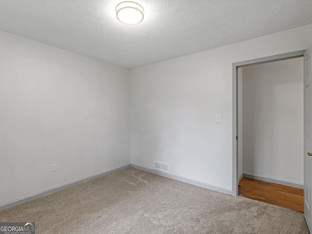 unfurnished bedroom with carpet flooring and a textured ceiling