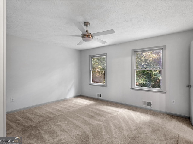 carpeted spare room with ceiling fan and a textured ceiling