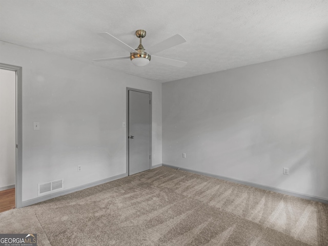 unfurnished room featuring ceiling fan, carpet, and a textured ceiling