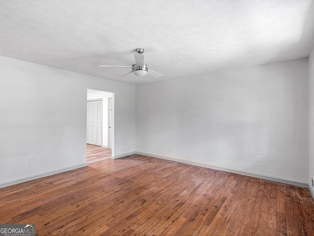 empty room featuring hardwood / wood-style flooring, a textured ceiling, and ceiling fan