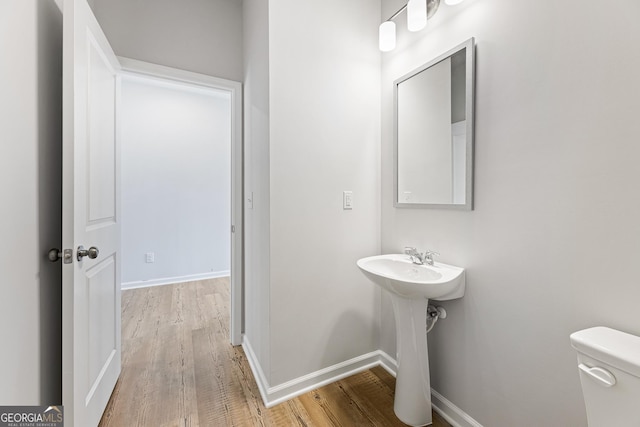 bathroom featuring wood-type flooring, toilet, and sink