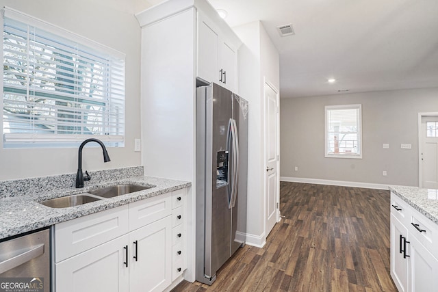 kitchen featuring white cabinetry, sink, light stone counters, and stainless steel appliances