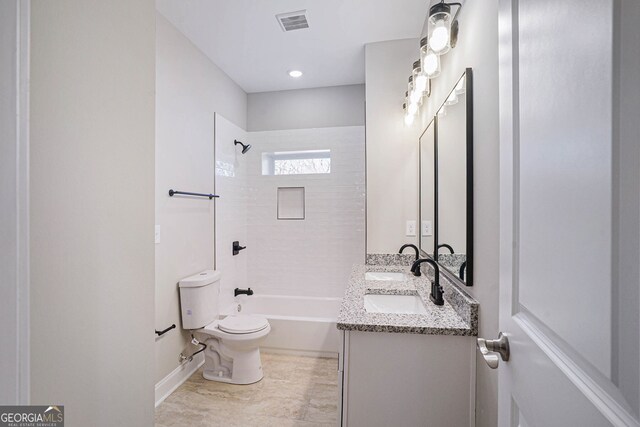 full bathroom with tiled shower / bath, vanity, and toilet