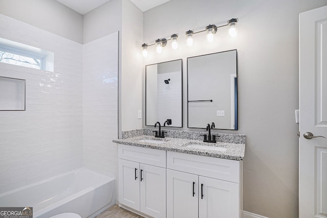 bathroom featuring tiled shower / bath and vanity