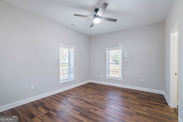 empty room featuring dark hardwood / wood-style flooring, plenty of natural light, and ceiling fan