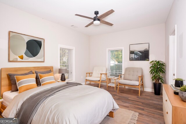 bedroom with dark hardwood / wood-style floors and ceiling fan