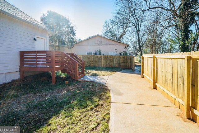 view of yard with a wooden deck and a patio area