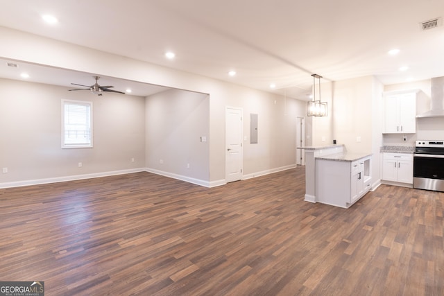 kitchen with stainless steel range with electric stovetop, decorative light fixtures, electric panel, white cabinets, and wall chimney range hood