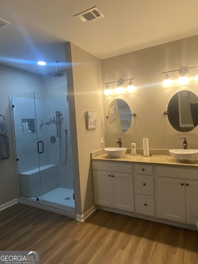 bathroom with vanity, hardwood / wood-style flooring, and a shower with shower door