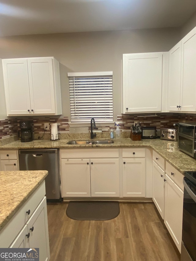 kitchen featuring appliances with stainless steel finishes, sink, white cabinets, and dark hardwood / wood-style flooring