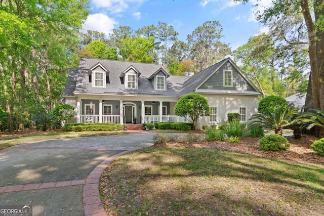 new england style home with a front lawn and covered porch