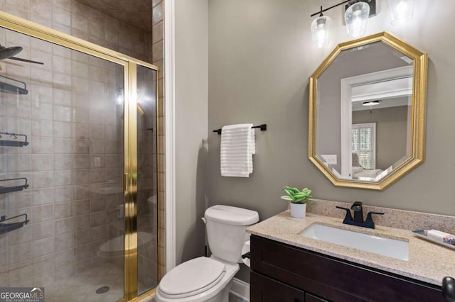 bathroom featuring vanity, an enclosed shower, and toilet