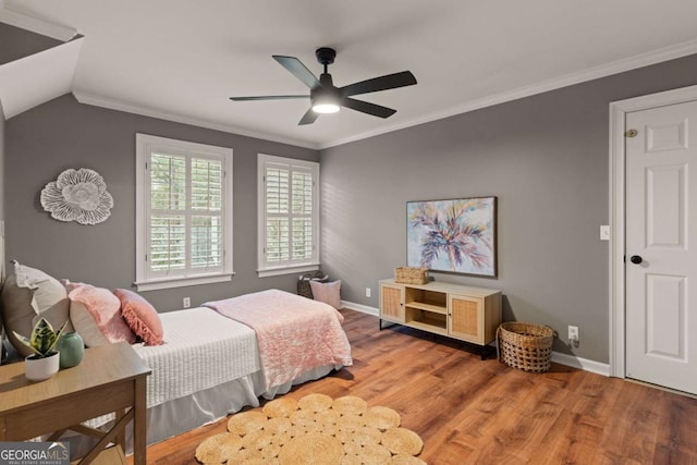 bedroom featuring crown molding, vaulted ceiling, hardwood / wood-style floors, and ceiling fan