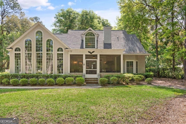 view of front of house featuring a sunroom and a front lawn