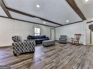 living room featuring beamed ceiling and hardwood / wood-style floors