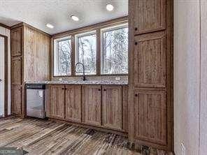 interior space with sink, wood-type flooring, and dishwasher