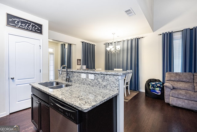 kitchen featuring pendant lighting, a sink, a center island with sink, and dishwasher