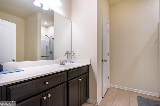 bathroom with tile patterned floors, vanity, and a shower