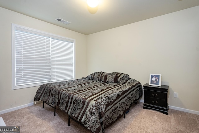 bedroom with visible vents, baseboards, and light colored carpet