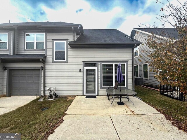 back of house featuring central AC, a garage, and a patio