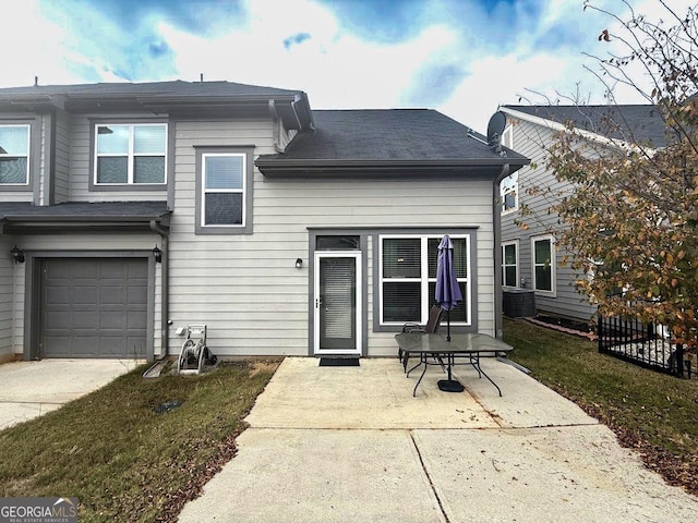 back of property featuring a patio, an attached garage, and central air condition unit