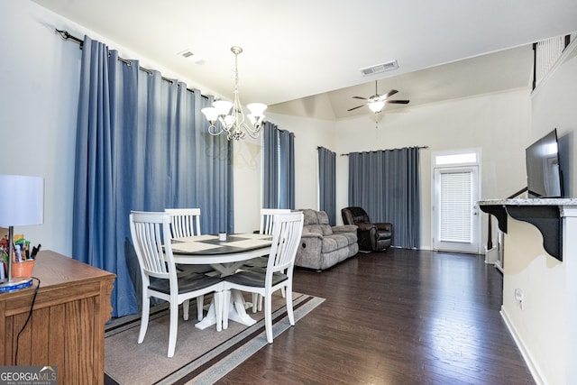 dining room featuring ceiling fan with notable chandelier, vaulted ceiling, and dark hardwood / wood-style floors