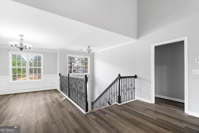 corridor featuring ornamental molding, dark hardwood / wood-style floors, and a notable chandelier