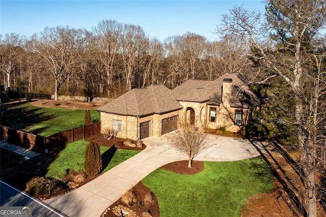 view of front facade featuring driveway, a garage, fence, and a front lawn