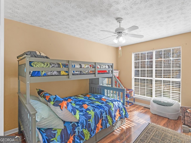 bedroom featuring wood-type flooring, ceiling fan, and a textured ceiling