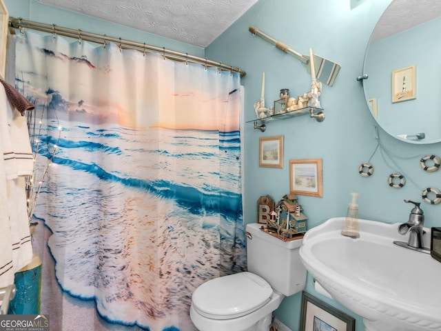 bathroom featuring sink, toilet, a textured ceiling, and walk in shower