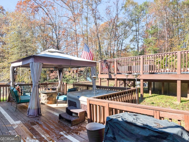 wooden deck with a gazebo and a fire pit