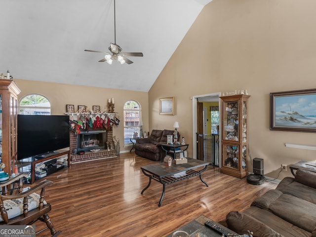 living room with hardwood / wood-style flooring, a fireplace, high vaulted ceiling, and ceiling fan