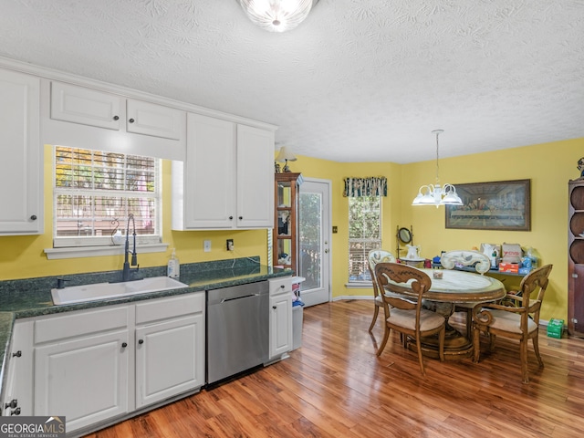 kitchen with sink, light hardwood / wood-style flooring, dishwasher, white cabinetry, and decorative light fixtures